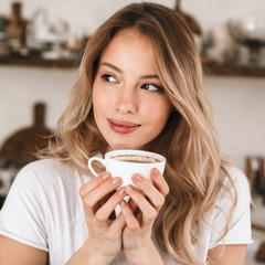 women holding mug sipping coffee