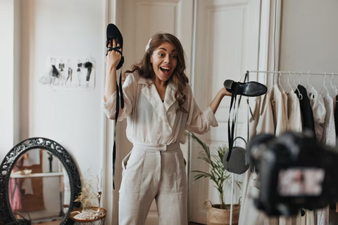 influencer giving surprised reaction in front of camera by holding black heels