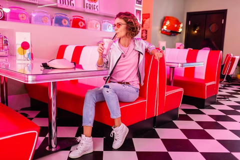 woman drinking smoothy in a pink themed café