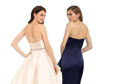 2 women wearing elegant dresses showing back in a shoot