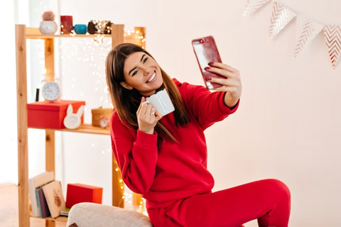 woman in red outfit holding coffee mug while taking selfie