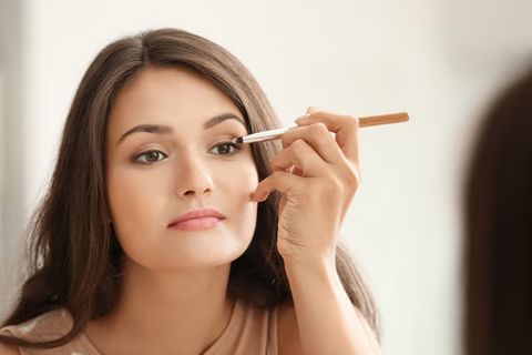 lady putting eye liner to her eyes