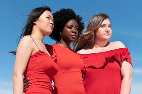 group of 3 women in red dress giving side pose