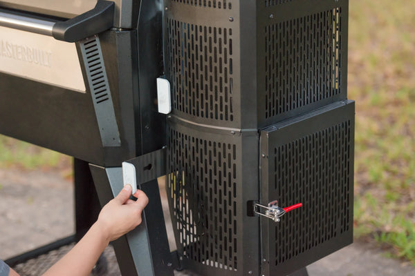 A hand pulls out the intake slide on the loser hopper of a Gravity Series grill