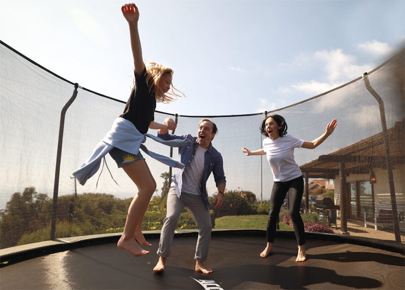Perhe pitää toisiaan käsistä kiinni ollessaan turvallisella ACON trampoliinilla