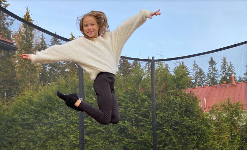 Girl jumps on Acon HD Trampoline with safety net