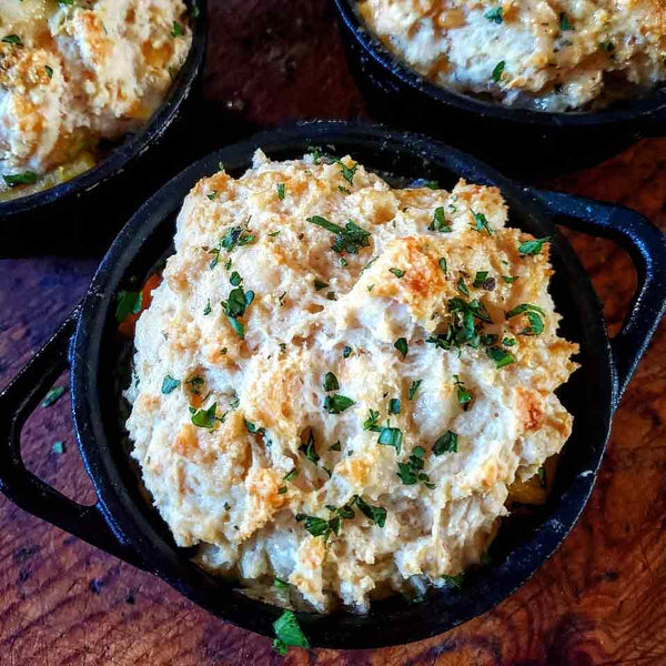 An individual pot roast stew topped with a cheddar biscuit.