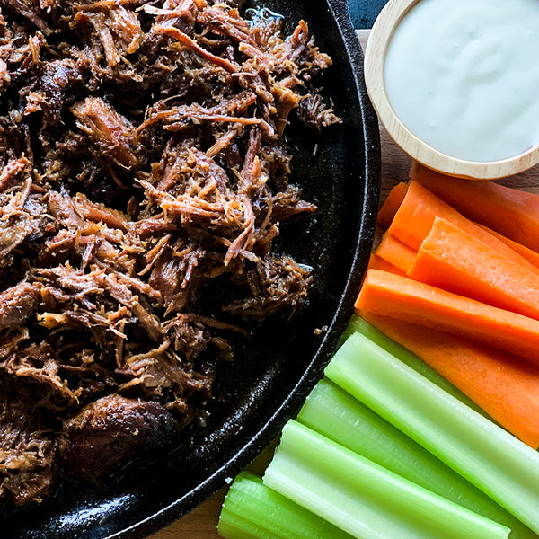 a close up image of shredded beef with buffalo sauce