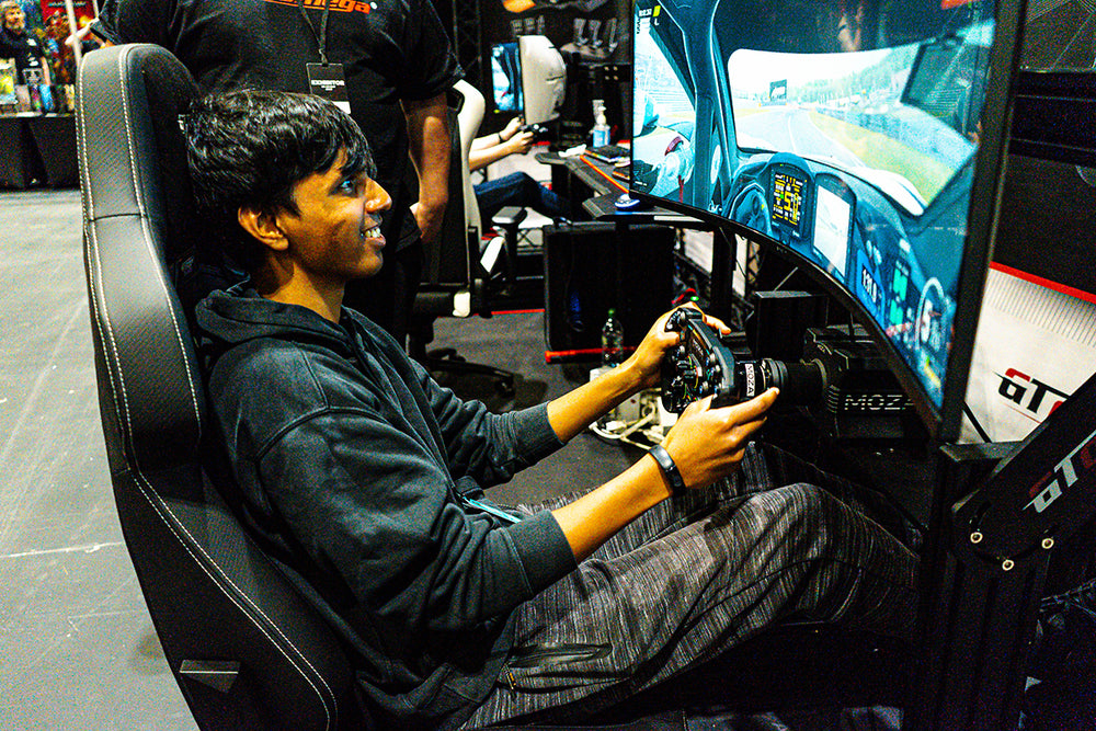 A visitor to the GT Omega Exhibition stand is racing in a GT Omega Prime Cockpit with Carbon RS12 racing Seat