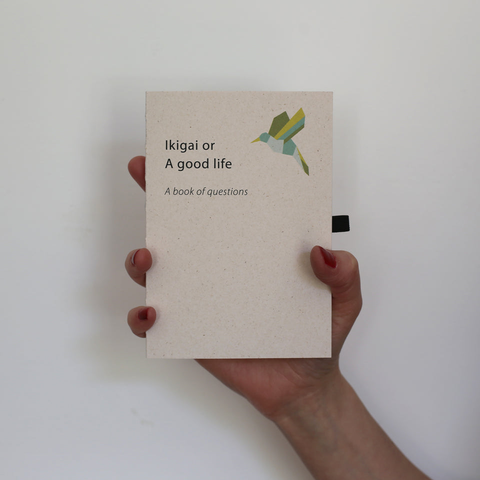 Ikigai or a good life. A book of questions. Cover made of sustainable paper made from leather residues. Favini Remalke Oyster. held in one hand. 