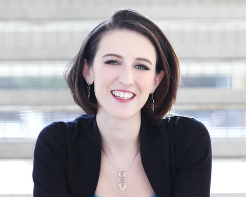 Author Krystal Higgins smiling and wearing a black cardigan and a silver necklace.