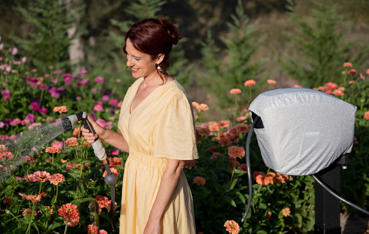 woman watering with retractable hose reel