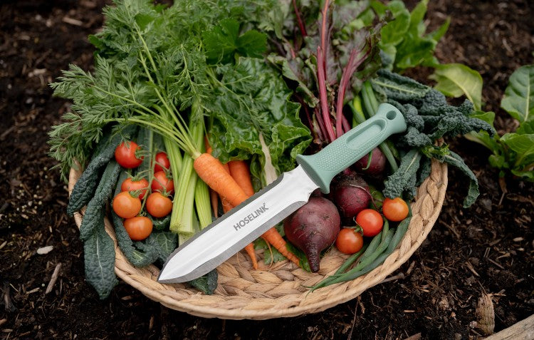 stainless-steel-hori-hori-garden-knife-sitting-on-top-of-a-basket-of-vegetables