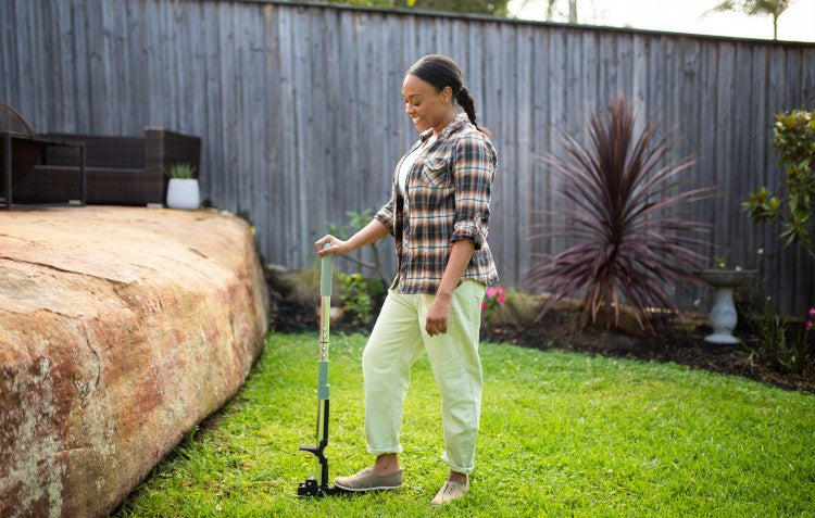 woman using stand up weed puller to pull weeds