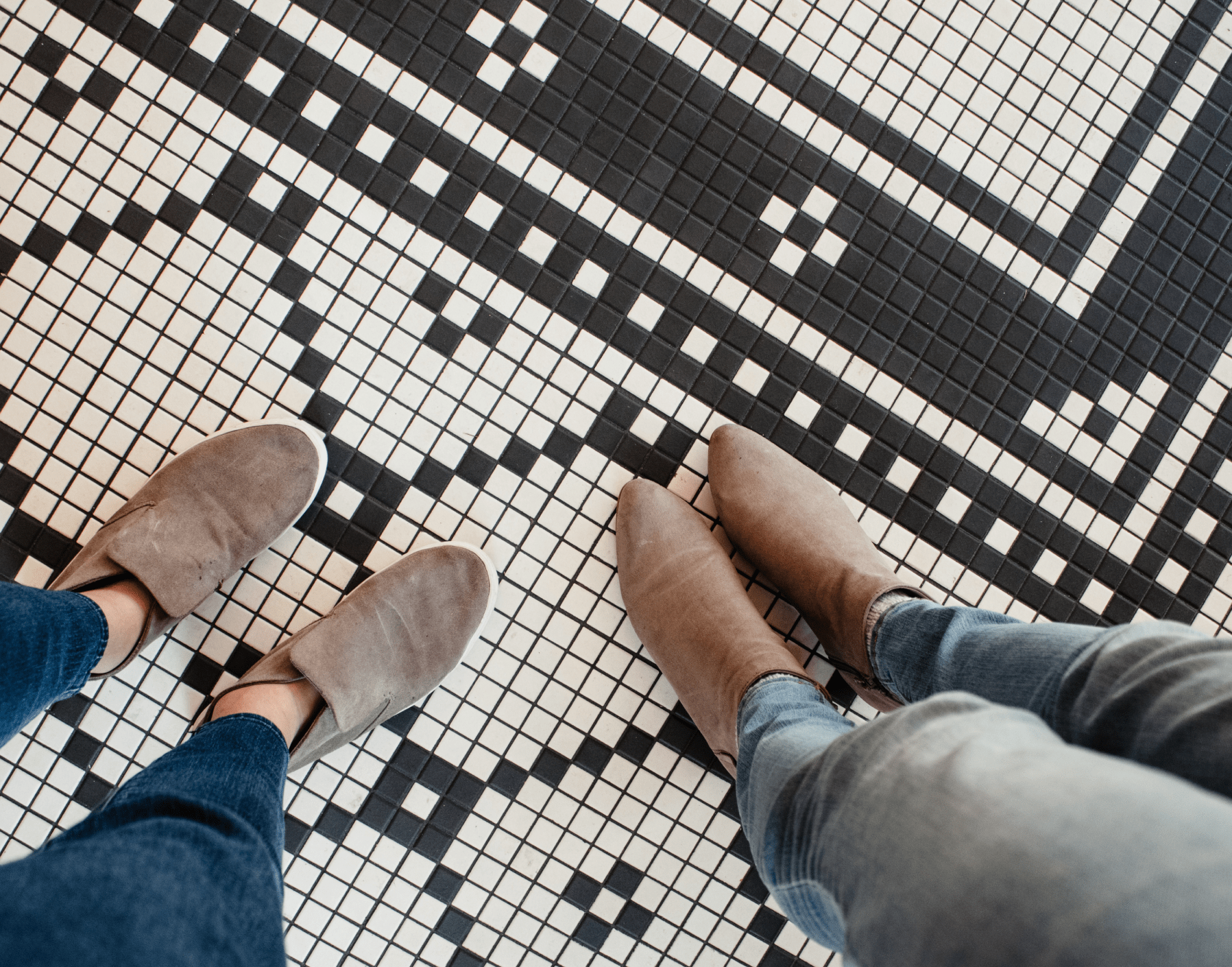 Two people standing on black and white mosaic flooring
