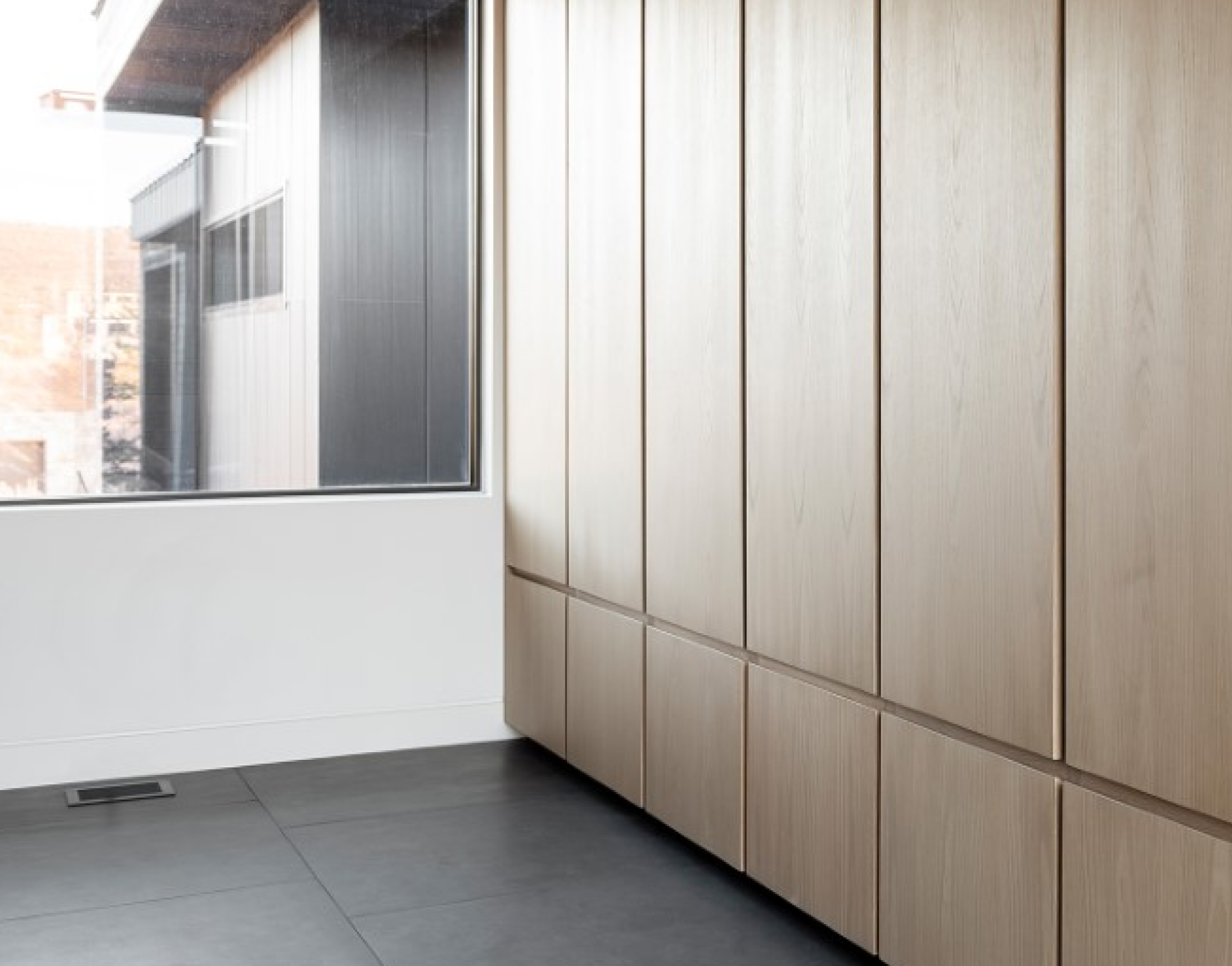 Contemporary room with black tiling, wood panelling and Black Monolith kul grilles vent cover