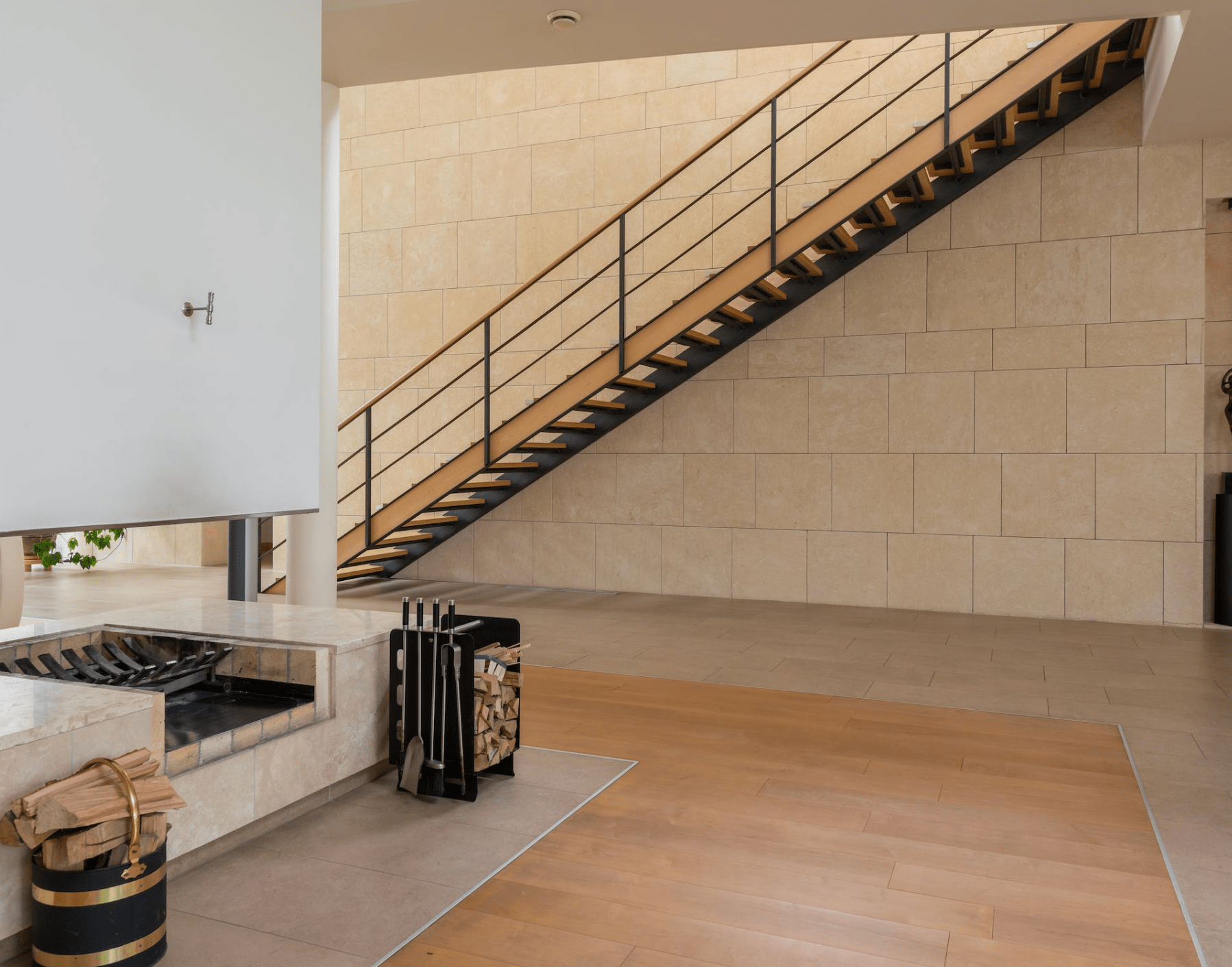 Exposed staircase and fireplace in open concept room