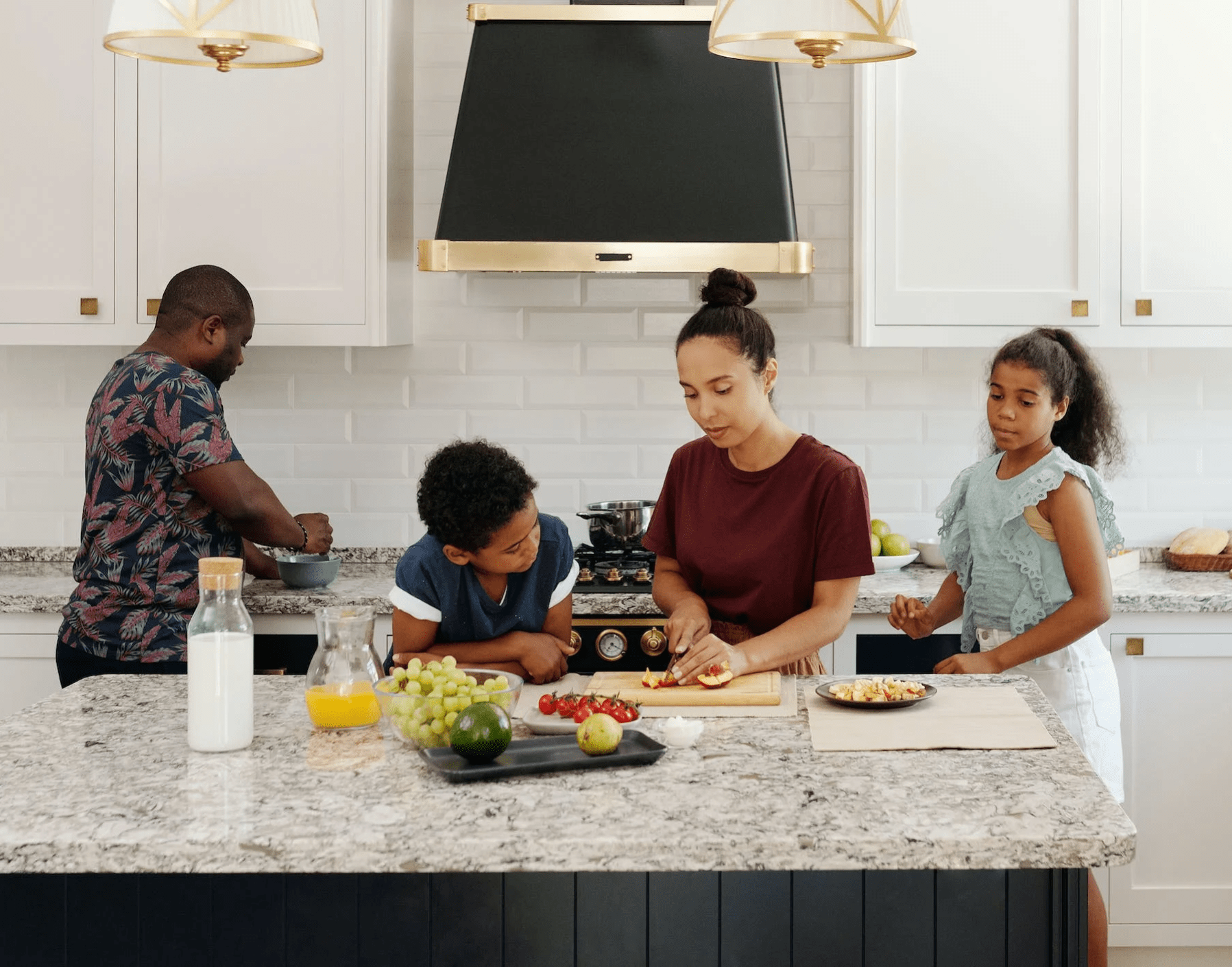 family preparing food in airy contemporary kitchen with granite countertop