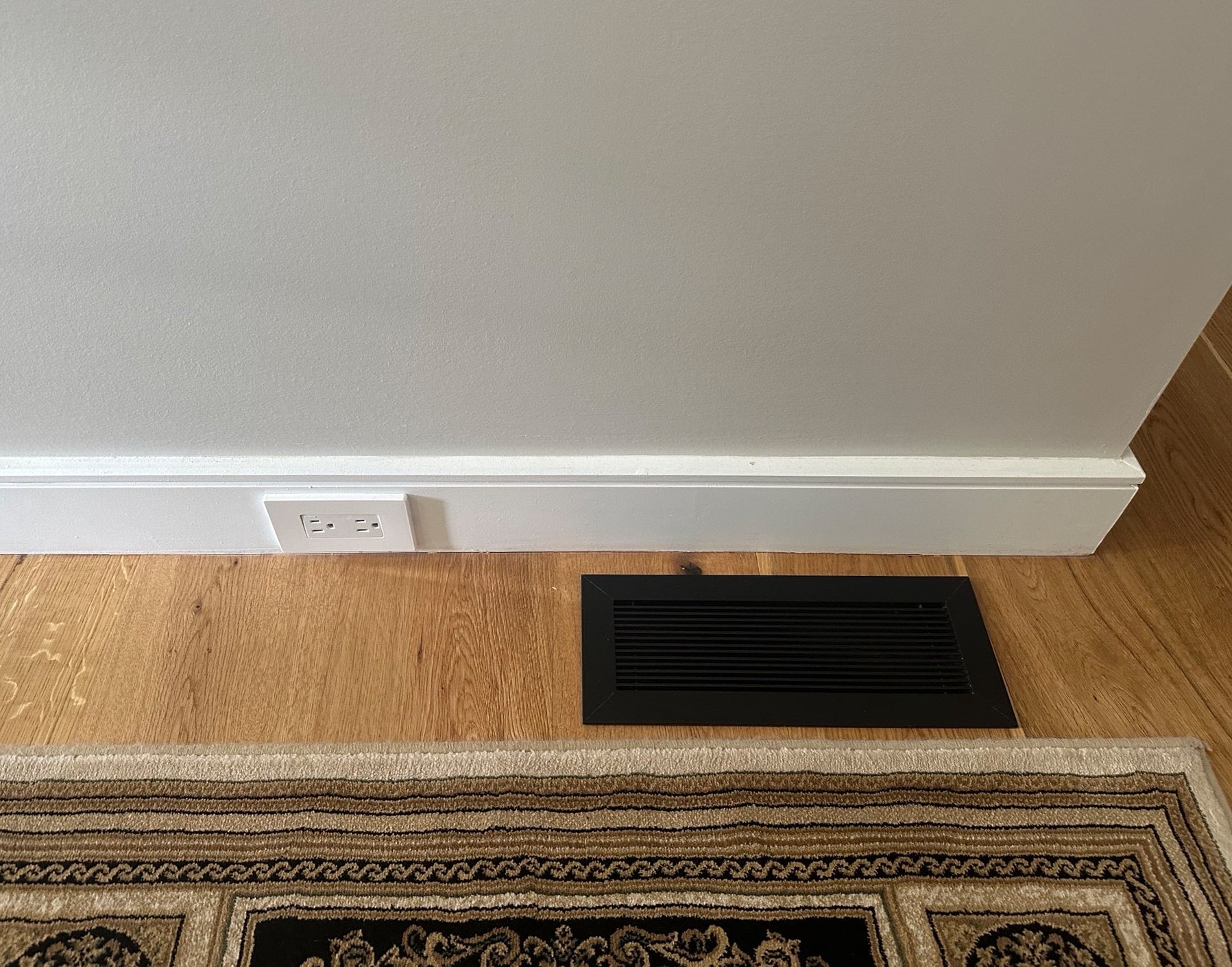 kul grilles black monolith vent cover on harwood next to area rug