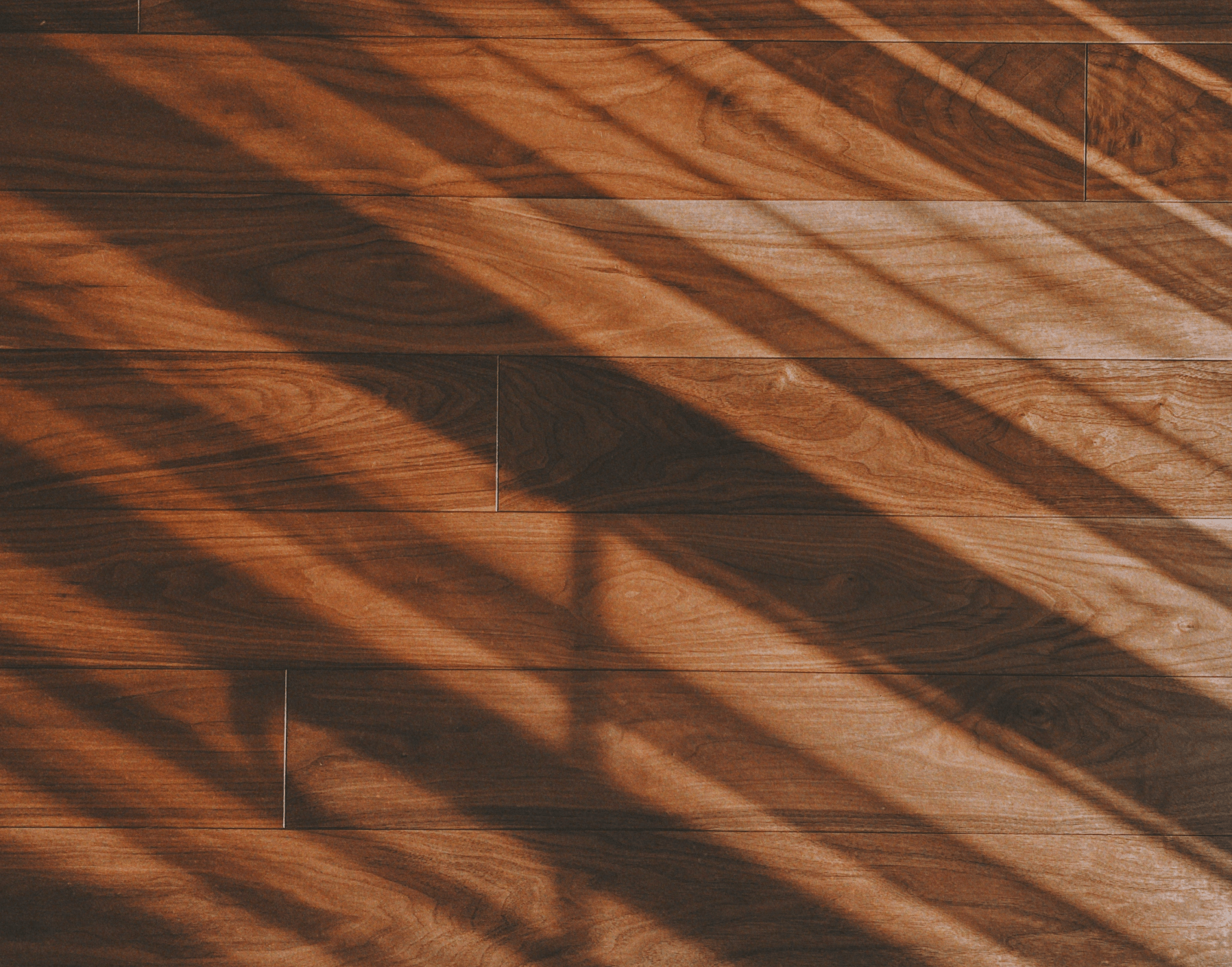 Warm toned hardwood flooring with cascading shadow