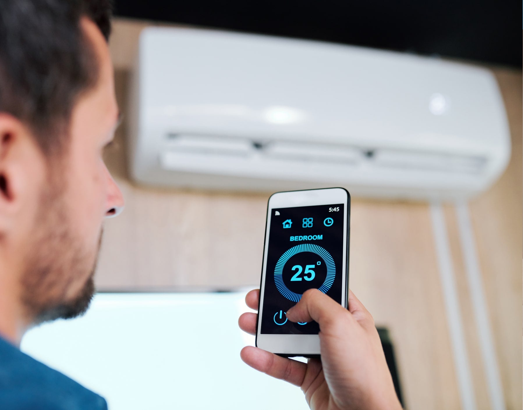 young man with smartphone using smart application adjust support temperature air conditioner