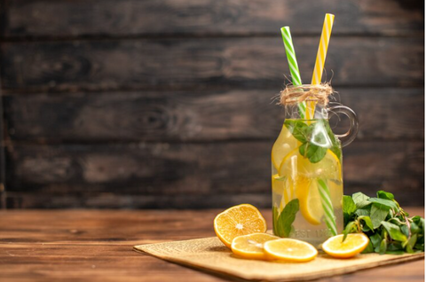 Refreshing detox drink kept on wooden chopping board on a wooden shelf with lemons and mint – how to make detox drink – weight loss drink -  House of Beauty – Mother’s day ideas – Spa day – Detox water drink – Healthy drink alternative – Mother daughter date