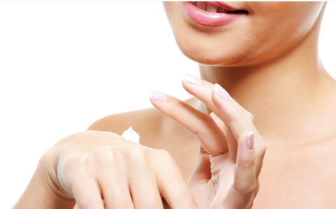 Girl applying cream on skin - tan removal - hydrating the skin