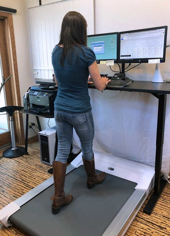 Unsit Treadmill Desk with Lisa Witt walking on it, shot from behind