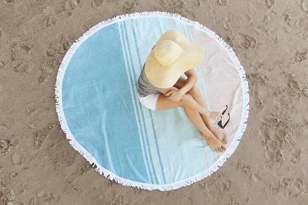 Lady sitting on a round beach towel