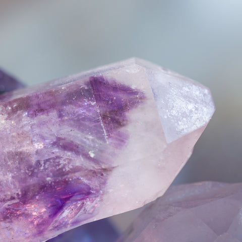 A sparkling crystal with a perfect purple amethyst phantom inside