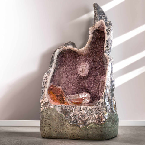 A throne made out of an amethyst geode from brazil in a well lit pleasant gallery space