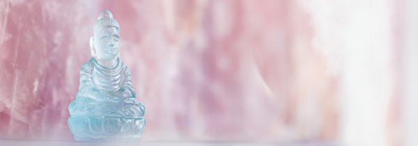 Aquamarine carving of buddha in front of rose quartz with a soft haze