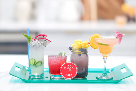 four colorful mocktails in a bright beautiful kitchen sitting on an acrylic turquoise serving tray