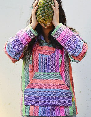 Girl wearing a baja hoodie holding a pineapple.