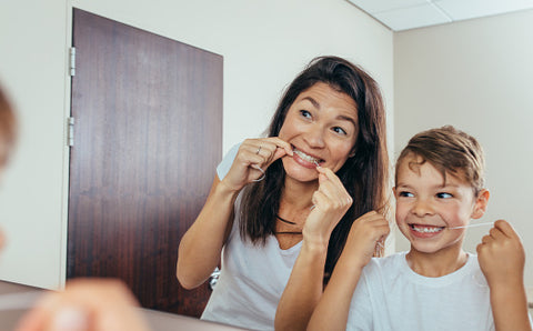 Woman and child flossing their teeth; stock photo courtesy of IStock