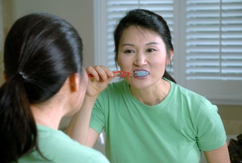 Woman brushing her teeth; image courtesy of Unsplash