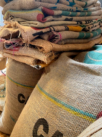 Grains de café vert dans sac en toile de jute