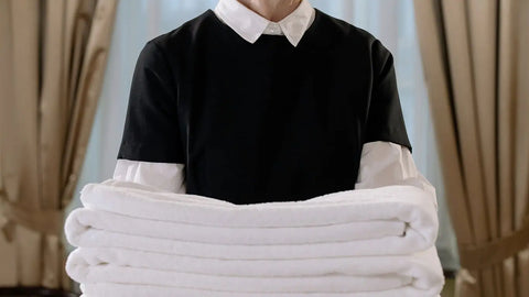 what should a housekeeper wear: holding folded towels