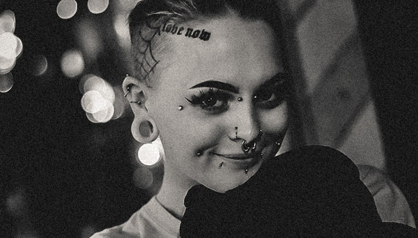 Close-up of a woman with many piercings on her face