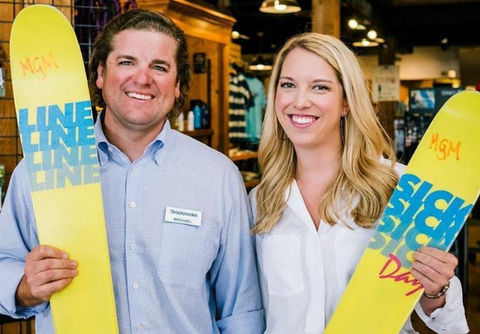 Male and female The Backpacker employees pose in store holding skis