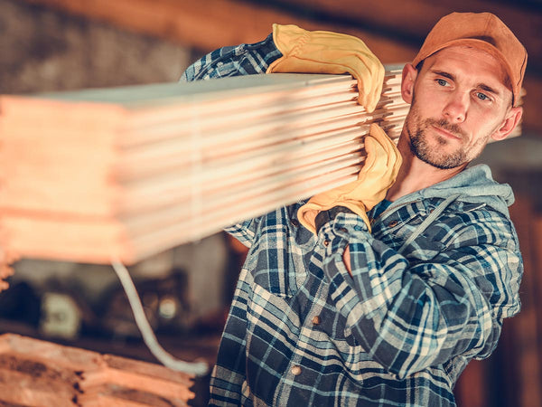 Image of a man moving lumber.
