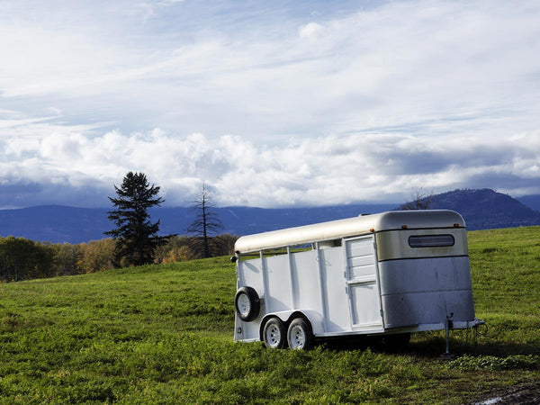 Image of a horse trailer in a field.