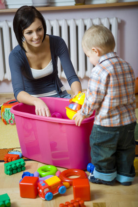 Educator guiding toddler through clean up routine