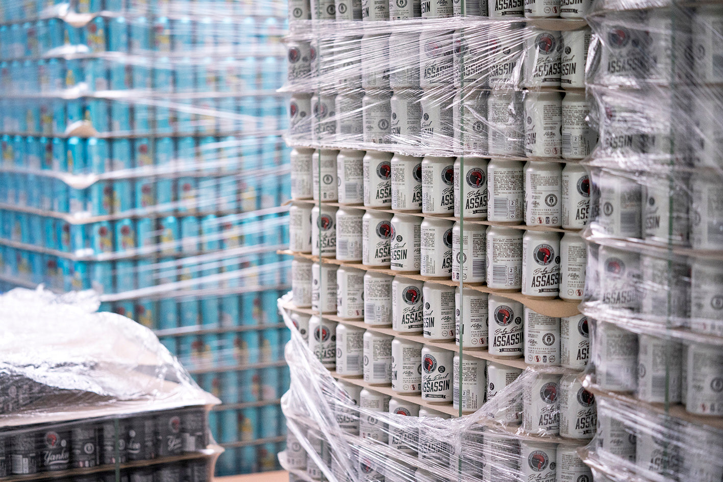 Stacks of craft beer cans including core range IPA Baby-Faced Assassin.