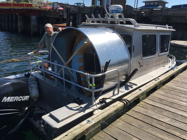 An AlumiTubs wood-fired hot tub getting transported by boat. 