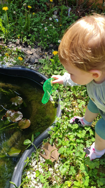 bambina che esplora con delle pagaie colorate in natura