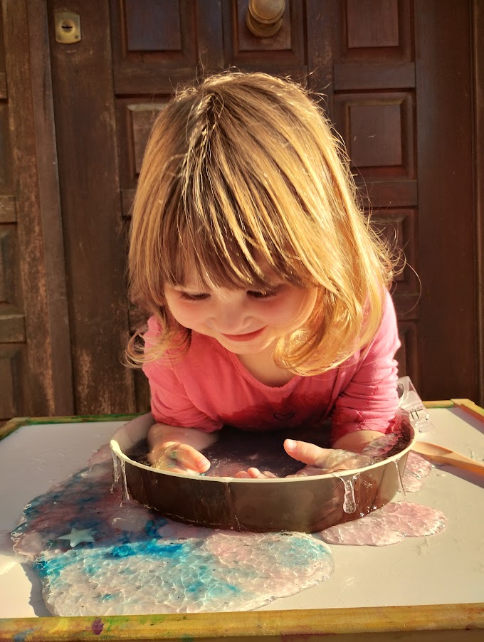 Bambina completamente immersa con le braccia nello slime