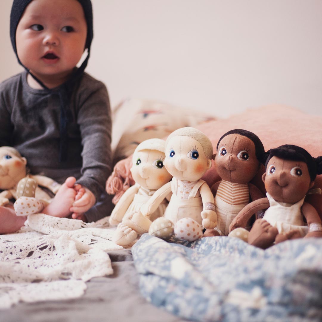 Un bambino piccolo con delle bambole multiculturali 