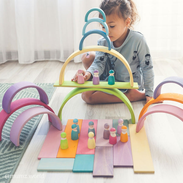 bambina che gioca con l'arcobaleno steineriano in legno creando minimondi