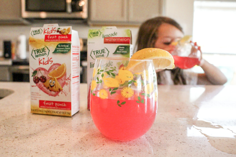 Girl drinking lemonade before a lemonade stand